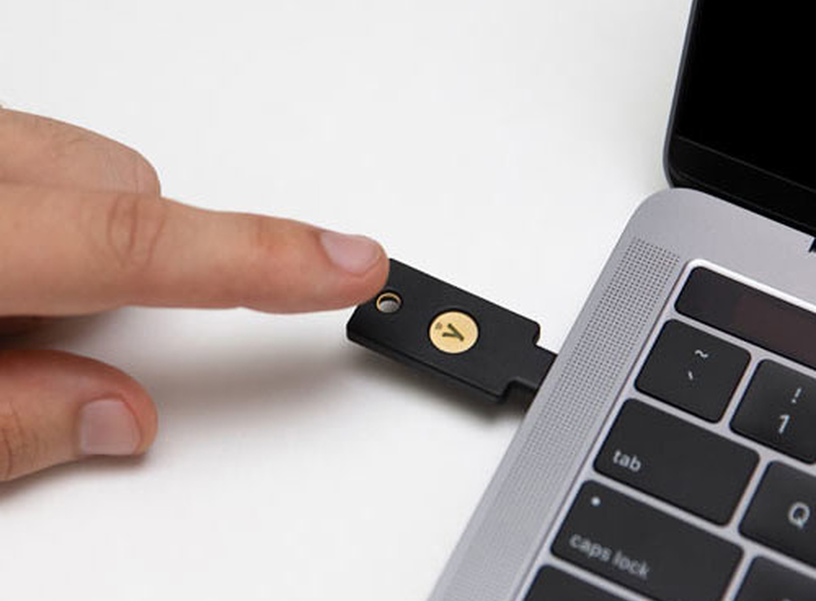 A person tapping a device plugged into a computer.